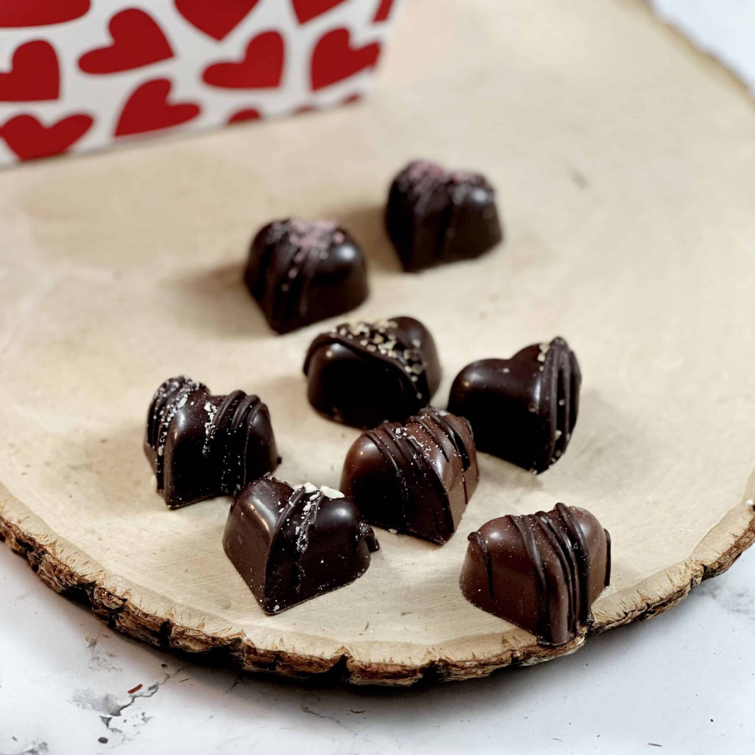 Small heart shaped truffles on a wood platter