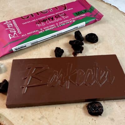 milk chocolate bar unwrapped with wrapped bar and dried cherries