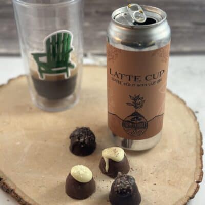 Can of Common Roots Latte Beer with Adirondack Chair glass partially filled with beer and chocolate truffles